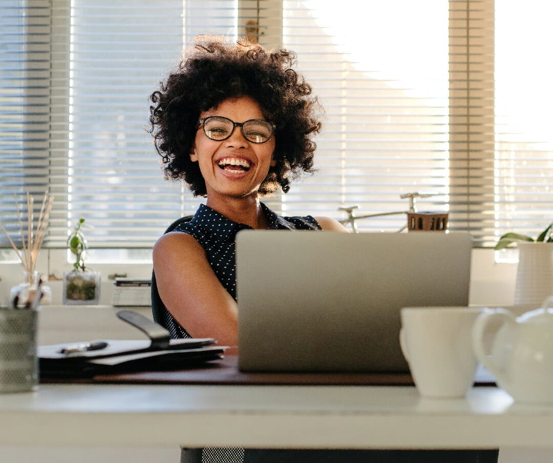 Femme souriante assise à son bureau